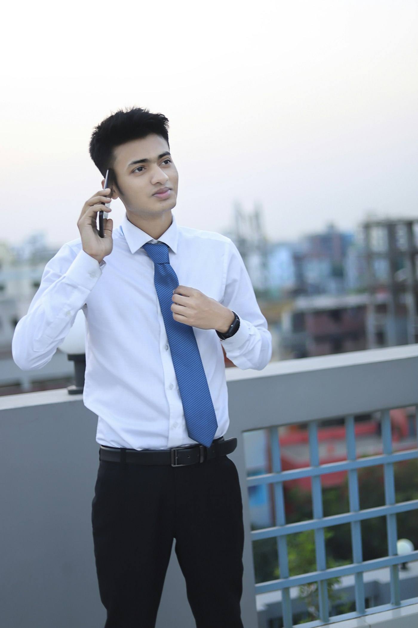 Real estate agent on a call in front of a building