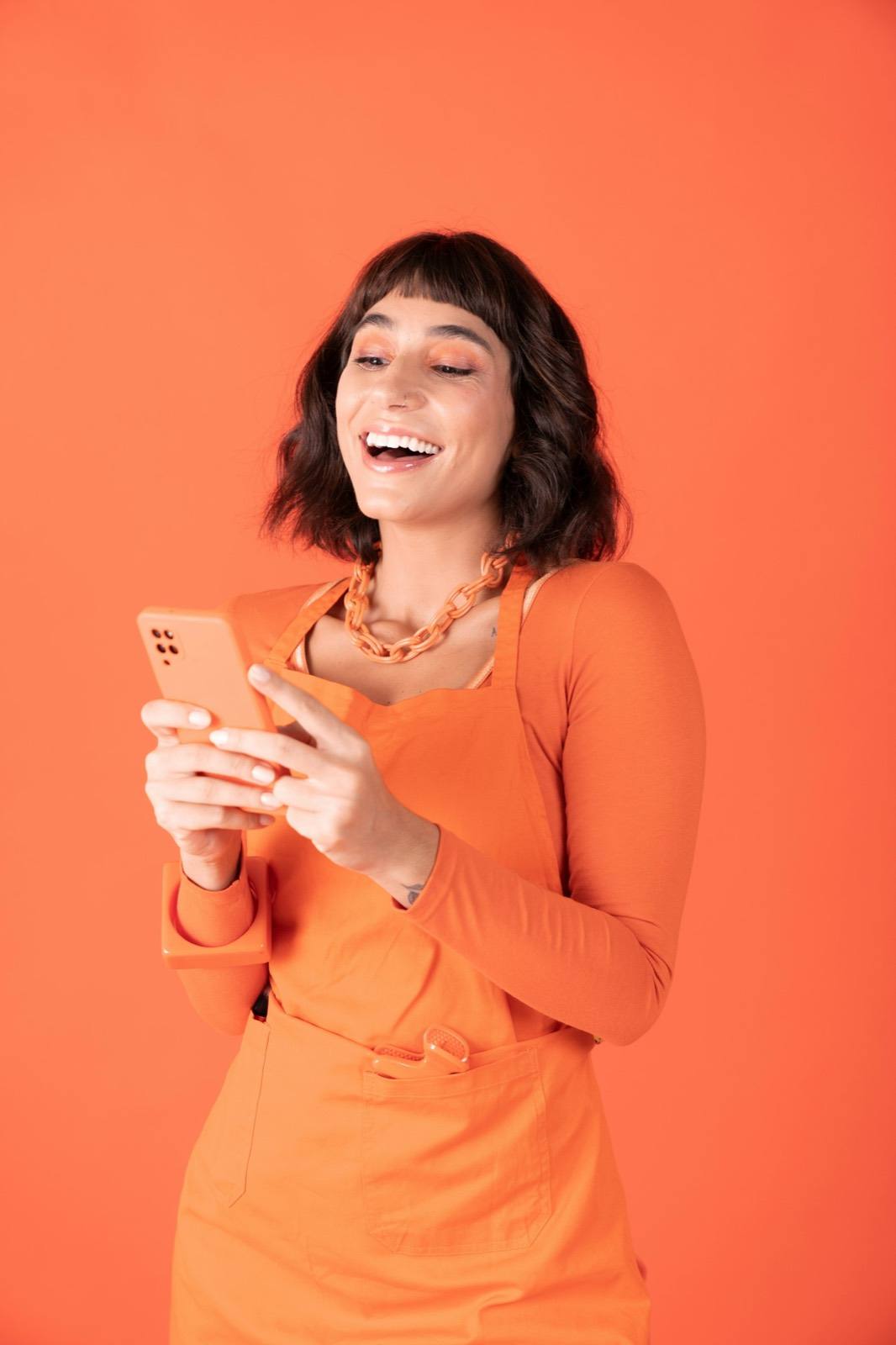Indian creator holding phone, smiling